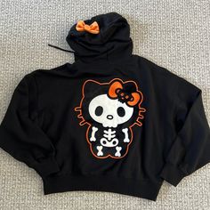 New With Tag. Hello Kitty Black Skeleton Hoodie. Size S Black Cartoon Print Hoodie Top, Black Hooded Top With Cartoon Print, Trendy Black Hoodie With Cartoon Print, Halloween Hoodie For Streetwear, Black Halloween Hoodie Top, Trendy Cartoon Print Hoodie Top, Cute Black Hoodie With Graphic Print, Cute Black Hooded Top, Orange Hooded Top For Streetwear