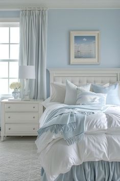 a bedroom with blue walls and white furniture