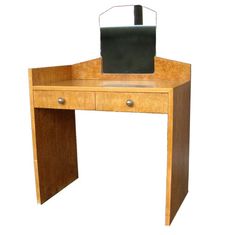 a wooden desk with a computer monitor on it's top and drawers underneath the desk