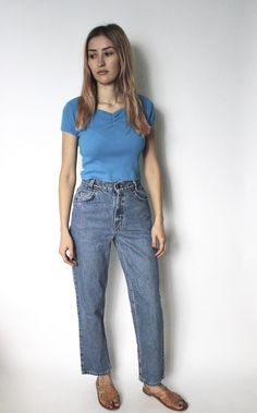 "DETAILS ◦ Vintage 1990s medium blue Levis 350 denim jeans ◦ Mid/high rise ◦ Three front pockets and two back pockets ◦ 4 button fly closure down front ◦ Five belt loops ◦ Straight leg, cropped fit Labeled 14 Regular Best Fit / Estimated Size | W 24\" - 24.5\" petite Measurements | Waist - 24.5\" Hips - 36\" Rise - 11\" Backrise - 12.5\" Inseam - 27\" Length -37.75\" Thighs - 21.5\" Circumference at ankle - 14\" Tag/Label | Levis 350, white tab Material | 100% cotton Condition | Good, some stain Classic High Waist Blue Jeans, 90s Style Mid-rise Blue Jeans, 90s Style Blue Mid-rise Jeans, 90s Blue Straight Leg Jeans, 90s High Rise Blue Jeans, 90s Style Denim Jeans For Everyday, Vintage Blue Jeans For Everyday, 90s Blue Jeans With Five Pockets, Jeans Levis