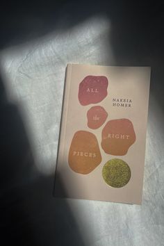 an open book sitting on top of a white sheet covered in writing and colored circles