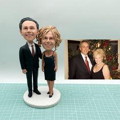 a bobble head figurine of two people standing next to a christmas tree