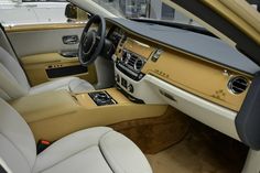 the interior of a luxury car with beige leather and wood trims, including steering wheel