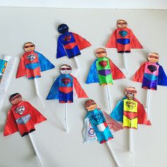 paper cut out superheros are on top of toothpicks