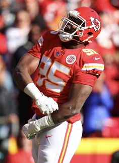 a close up of a football player on the field with his hands in his pockets