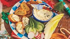 a plate with bread, cucumbers and pickles on it next to other food items