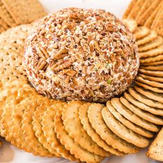 a cheese ball surrounded by crackers on a plate