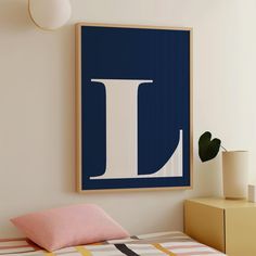 a bed with a blue and white poster hanging on it's wall above it