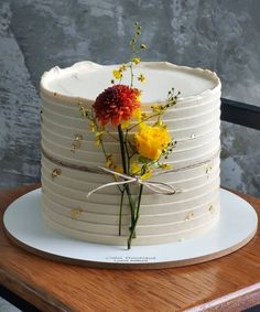 a white cake with yellow and red flowers on top