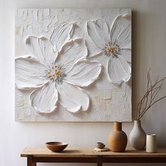 two white flowers painted on a wall above a table