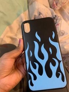 a person holding up a phone case with flames on the front and back cover in their hand