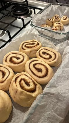 some cinnamon rolls sitting on top of a counter next to a pan filled with them