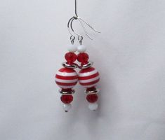 Sweet candy cane striped Christmas earrings.  Red and white striped acrylic beads stacked with red, white, and silver beads.  Bead stack is about 1 5/8 inches high and 1/2 inch wide.  Most beads feature variations related to their natural character and to production and thus may have some range in design and size. Some colors may vary due to different monitor settings. Sedgeworks features original bead jewelry designed with natural stones, semi-precious gemstones, sterling silver, 14k gold filled, and a colorful medley of other quality elements. Please visit my shop at sedgeworks.etsy.com for more one of a kind jewelry items. Red Beaded Earrings For Holiday With Round Beads, Red Beaded Earrings For Holiday, Candy Cane Stripes, Holiday Earrings, Beaded Jewelry Designs, Holiday Earring, Earrings Red, Sweet Candy, Christmas Earrings