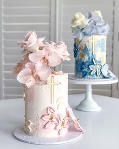 two cakes decorated with pink and blue flowers on top of a white cake platter