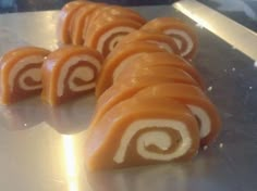 several pieces of sushi on a metal tray with white and brown spirals in the middle