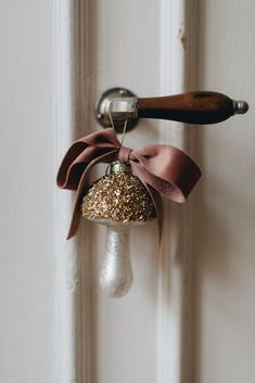 an ornament hanging from the side of a door with a ribbon on it