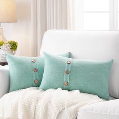 two decorative pillows on a white couch