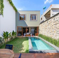 a house with a swimming pool in the middle of it's yard and patio area