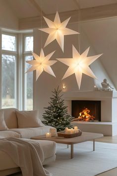 a living room filled with furniture and a christmas tree in front of a fire place