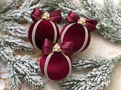 two red christmas ornaments with bows on them