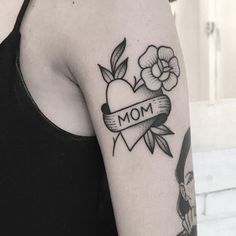 a woman's arm with an apple and flower tattoo on it that says mom