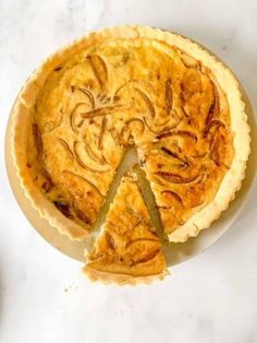 a pie sitting on top of a white table next to a slice missing from it