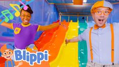 two people standing next to each other in front of colorful slides