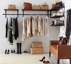 an organized closet with shoes, purses and handbags hanging on the wall next to a couch