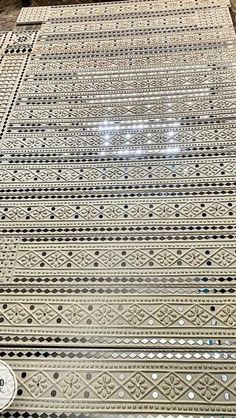 a large metal table sitting on top of a wooden floor covered in lots of dots