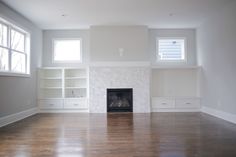 empty living room with fireplace and built in bookcases