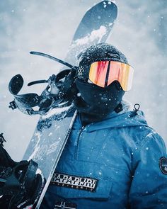 a snowboarder wearing goggles and holding his board