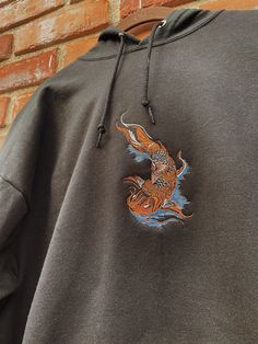 "Koi Fish Embroidered Hoodie -Embroidered on a cotton/polyester blend hoodie, this design is simple and minimalistic, perfect for every outfit! -Embroidery design measures 6\" x 3\" -See product pictures for shirt sizing chart. -Hanes/Gildan Brand depending on availability. -All sweatshirts are handmade on an embroidery machine so there may be slight differences, but we only sell the shirts that meet our high-quality standards. -To maintain the quality of your shirt and the embroidery design mak Koi Fish Hoodie, Long Sleeve Hoodie With Embroidered Patch For Streetwear, Embroidered Long Sleeve Hoodie For Streetwear, Embroidered Patch Hoodie For Streetwear, Streetwear Embroidered Patch Crew Neck Hoodie, Crew Neck Hoodie With Embroidered Patch For Streetwear, Embroidered Patch Crew Neck Hoodie For Streetwear, Streetwear Crew Neck Hoodie With Embroidered Patch, Black Embroidered Hooded Hoodie