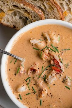 a bowl of soup with bread on the side