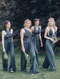 four beautiful women in long dresses standing next to each other