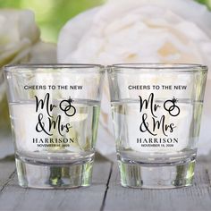 two personalized shot glasses sitting next to each other on top of a wooden table