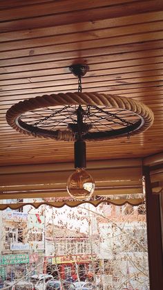 a ceiling fan that is hanging from the ceiling in front of a storefront window