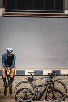 a man sitting on the ground next to his bike