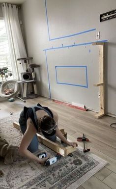 two people are laying on the floor in front of a whiteboard with blue tape