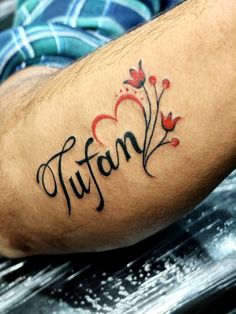 a man with a tattoo on his arm that reads tuffon and has flowers in it