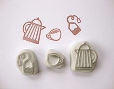 three rubber stamps with coffee and teapots in them on a white table top