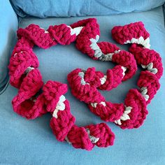 several crocheted hearts arranged in the shape of a heart on a blue couch