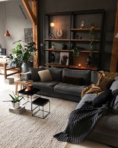 a living room filled with lots of furniture next to a wall mounted bookshelf