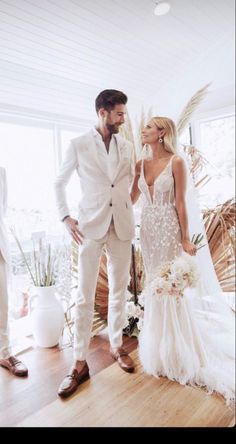 a man and woman in wedding attire standing next to each other on a wooden floor