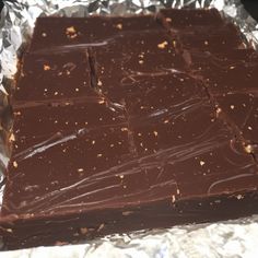 a piece of chocolate cake sitting on top of aluminum foil