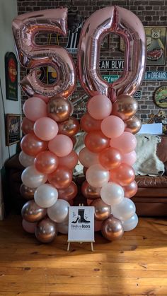 balloons are arranged in the shape of numbers on a table with a sign that says 50