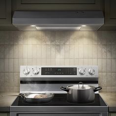 a stove top oven sitting next to a pot and pan on the burners in front of it