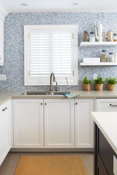 a kitchen with blue and white tile on the walls, cabinets and counters is shown