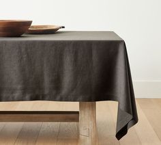 a bowl on top of a table with a black cloth over it and a wooden base