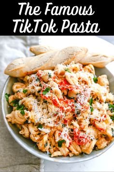 the famous tik tok pasta dish is served in a bowl with breadsticks