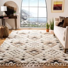 a living room with a large window and a rug on the floor in front of it